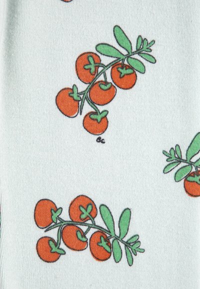 Groupes de petites tomates orange avec des tiges et des feuilles vertes sur un fond de tissu bleu clair.