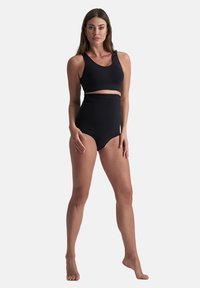 Zwart tweedelig badpak met een cropped top en hooggepaneerde bikini-broekjes. Glad materiaal, eenvoudig ontwerp en geen zichtbare patronen of accenten.