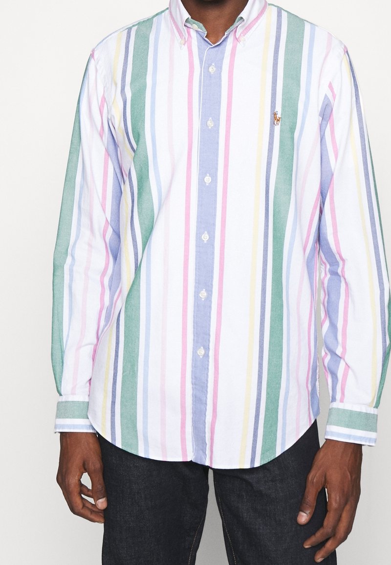 Camicia button-up con righe verticali in verde, blu, rosa e bianco. Presenta un colletto e maniche lunghe. Logo discreto sul petto.