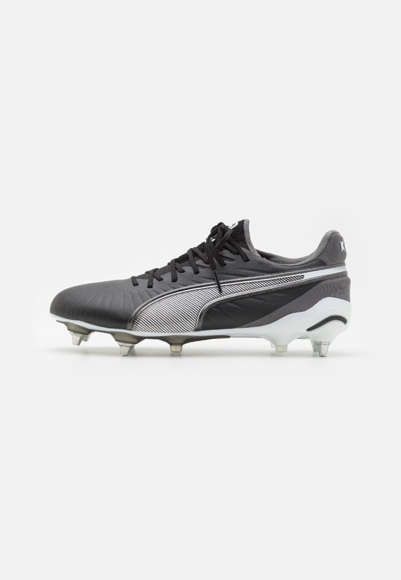 Botín de fútbol negro y plateado con un upper texturizado, cierre de cordones y tacos moldeados para tracción. Presenta un logo sutil en el talón.