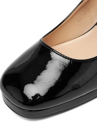 Czarny lakierowany czółenek z zaokrąglonym noskiem i błyszczącym wykończeniem. Gładka faktura i wzmocniona podeszwa dla zwiększonej trwałości.