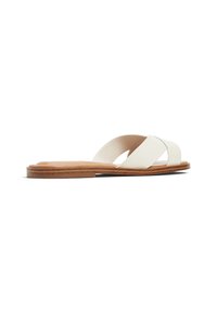 Hvide læder slidesandaler med krydsede stropper, flad tan sål, minimalistisk design og glat tekstur, med en lav profil og åben hæl.