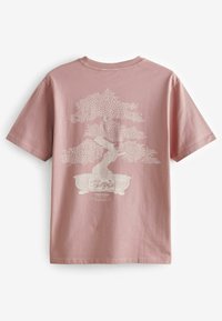 Rózsaszín pamut póló, hátul fehér bonsai grafikával, bonyolult levél részletekkel és alatta egy díszes virágcseréppel.