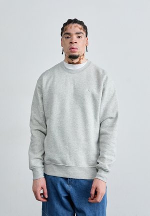 Sweatshirt en polaire grise avec un col rond et des manches longues, arborant un petit logo sur la poitrine et des poignets et un ourlet côtelés.
