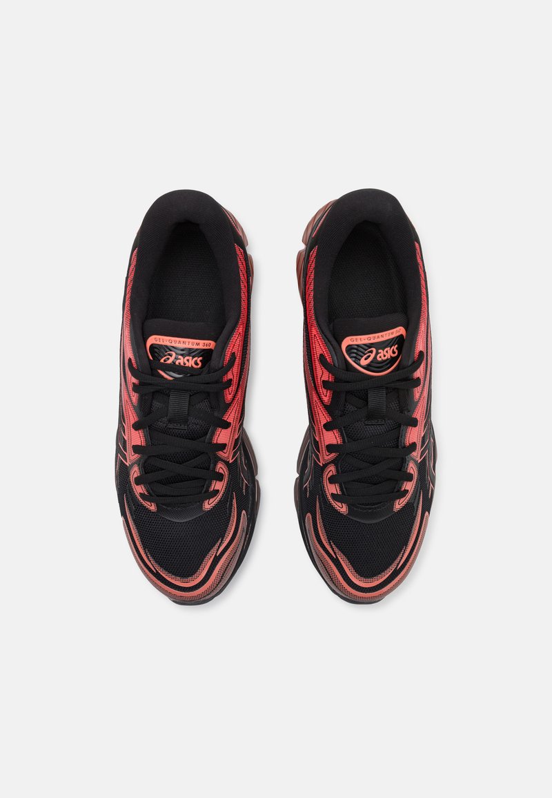 Zapatillas deportivas negras con parte superior de malla y acentos rojos, un diseño aerodinámico y una suela de goma con elementos de amortiguación visibles.