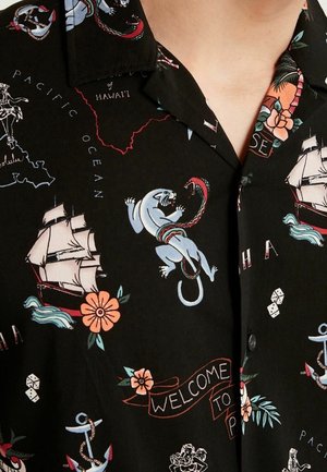 Chemise noire à manches courtes ornée d'imprimés colorés de navires, de fleurs et de créatures mythiques, avec un col camp et une fermeture à boutons.