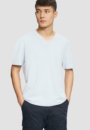 Lichtblauw V-hals T-shirt gemaakt van zachte stof, met korte mouwen en een relaxed fit, gecombineerd met donkere cargoshorts.