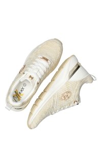 Beige stickade sneakers med vita snören, gummisula och metalldetaljer i guld. Har en texturerad ovandel och logodetalj på sidan.