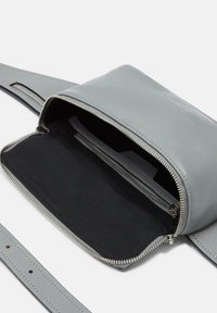 Graue Leder-Crossbody-Tasche mit einem Reißverschluss, ausgestattet mit einem schwarzen Stofffutter und einer inneren Reißverschlusstasche. Verstellbarer Riemen inklusive.