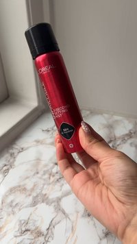 Aérosol rouge avec un capuchon noir étiqueté "L'Oréal Paris Infallible 3-Second Setting Mist," présentant une finition brillante et une forme arrondie.