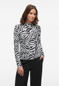 Schwarz-weiße, zebra gestreifte Langarmoberteil mit hohem Kragen, aus glattem Stoff gefertigt, körperbetontes Design, das die Silhouette betont.