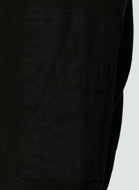 Czarna dzianina z teksturowaną kieszonką w ciemniejszym odcieniu czerni, z widocznym przeszyciem i prostokątnym kształtem.