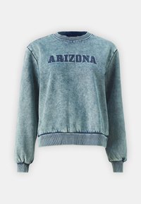Heledasinine kampsun, millel on tumedast sinisest välja brodüreeeritud "ARIZONA". Omab soonikkoes varrukaid ja ääri, pehmet tekstuuri ning ümarat kaelust.