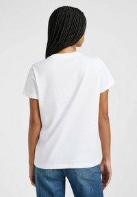 T-shirt bianco in cotone con maniche corte, colletto girocollo e vestibilità rilassata. Tessuto liscio, senza motivi visibili o dettagli hardware.