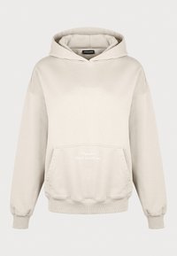 Beige hoodie med en rymlig framficka, ribbade mudd och fåll. Har broderad text "Pegador - Fånga det med mig" i vitt.