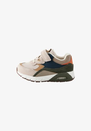 Kindersneakers met een zachte beige suède bovenkant, marineblauwe en oranje accenten, en een witte tussenzool. Klittenbandsluiting voor gemakkelijke bevestiging.