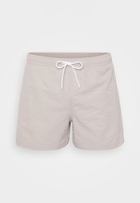 Shorts de bain beige en tissu texturé, avec une taille élastique et un cordon blanc. Présente une coupe décontractée et une longueur mi-cuisse.