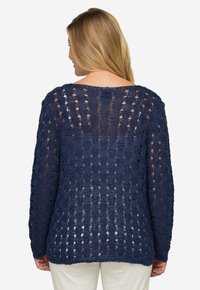 Marineblauer Strickpullover mit einem offenen Design, lockerem Schnitt, langen Ärmeln und rundem Ausschnitt. Strukturiertes Garn und gewellter Saum.