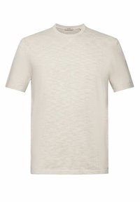 T-shirt beige clair à manches courtes en tissu doux et texturé ; il présente un col rond avec une finition soignée et sans motifs visibles.