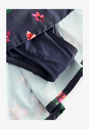 Badetøjssæt med en mørk blomstret overdel og ensfarvede mørke underdele, lavet af elastisk materiale med glat tekstur og syede detaljer.