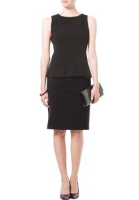 Gaun peplum hitam dengan siluet pas, rok sepanjang lutut, dan leher bulat. Dipadukan dengan clutch hitam dan sepatu hak rendah.
