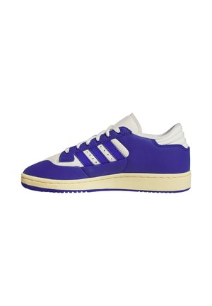 Low-top sneaker van blauw en wit leer met een crème kleurige zool, vetersluiting aan de voorkant en drie blauwe strepen aan de zijkant.