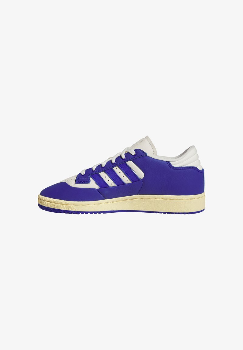 Low-top sneaker van blauw en wit leer met een crème kleurige zool, vetersluiting aan de voorkant en drie blauwe strepen aan de zijkant.