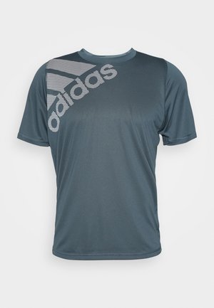 T-shirt de sport à manches courtes Adidas gris foncé avec un grand logo Adidas blanc et des rayures sur l'épaule gauche et la poitrine.