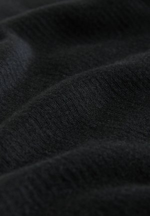 Tejido de punto negro con una textura suave y un sutil patrón acanalado, con pliegues visibles y una reflexión de luz variable en toda su superficie.