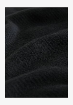 Mustavaatteiden neulekangas, jossa on pehmeä rakenne ja hienovarainen raidoitus, näkyvillä olevan taitteen ja vaihteleva valon heijastus koko pinnalla.