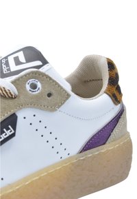 Sneaker blanc avec des accents en suède beige, des détails violets et un talon en imprimé léopard marron. Comprend des perforations et une semelle texturée.