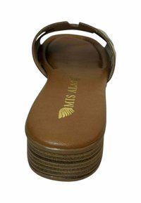 Sandalías de plataforma marrones con una plantilla de cuero suave y una correa ancha, que presenta un logo dorado y un sutil detalle acanalado en la suela.