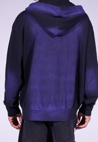 Sudadera con capucha en negro y púrpura oscuro con efecto degradado y puños acanalados. Incorpora capucha con cordón y ajuste holgado.