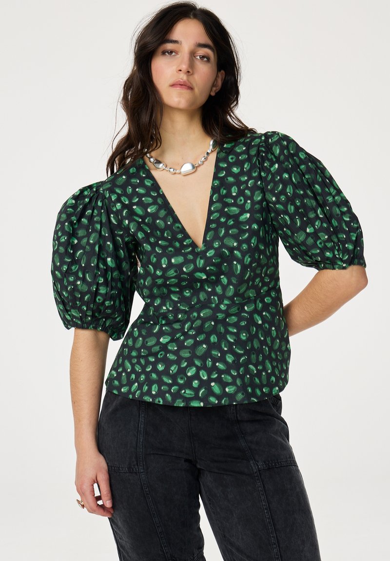Groene blouse met een patroon, voorzien van een diepe V-hals, pofmouwen en een getailleerde taille. Gemaakt van een gestructureerde stof met donkere accenten en een speels ontwerp.