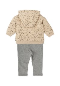 Sudadera beige con patrón texturizado gris, capucha fija y puños acanalados; combinada con leggins grises. Tejido suave, diseño casual.