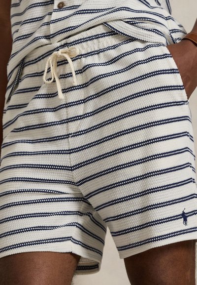 Csíkos rövidnadrág texturált anyagból, tengerészkék és fehér vízszintes csíkokkal, rugalmas derékrésszel és húzózsinórral, valamint kis logórészlettel.