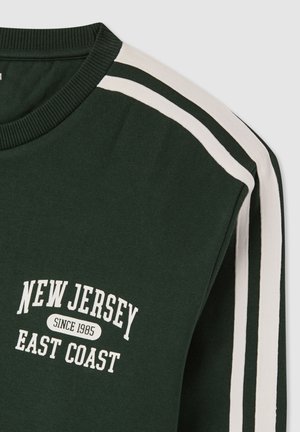 Ciemnoczerwona bluza z białym napisem "New Jersey Since 1985 East Coast" oraz białymi podwójnymi paskami wzdłuż ramienia i rękawa.