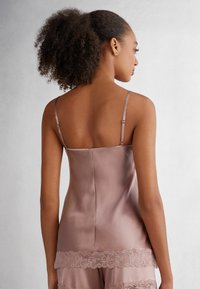 Satin camisole in rozenkleur met dunne verstelbare bandjes en een geschulpte kantzoom. Soepele textuur met een aansluitende pasvorm.