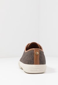 Baskets en tissu texturé marron avec une capuche en cuir beige et un accent en logo doré. Elles sont dotées d'une semelle en caoutchouc blanche.
