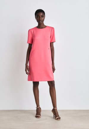 Coral dress with short puff sleeves, round neckline, and side pockets. Smooth fabric with a straight cut, knee-length, and minimalistic design.