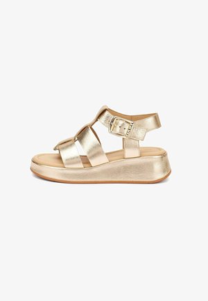 Sandalia de cuña metálica dorada para mujer con tres tiras anchas, cierre de hebilla en el tobillo, plantilla acolchada y suela de caucho.