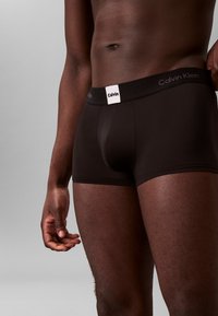 Boxer briefs neri Calvin Klein con una morbida fascia in vita che presenta il logo del marchio. Il tessuto è liscio, aderente e si allunga comodamente.