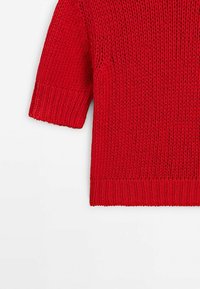 Pull rouge tricoté à manches courtes avec un tissage lâche, présentant un ourlet large côtelé et un motif texturé, affiché sur un fond blanc.