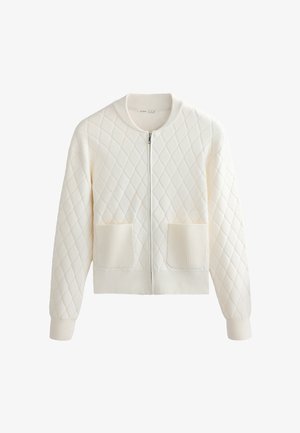 Kremowa dzianinowa kurtka na zamek z wzorem diamentowym, ściągaczami na mankietach, dole i kołnierzu oraz dwoma naszywanymi kieszeniami z przodu.