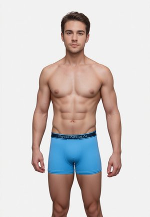 Blue boxer briefs made from soft fabric, featuring a black waistband with "EMPORIO ARMANI" branding, fitted design.