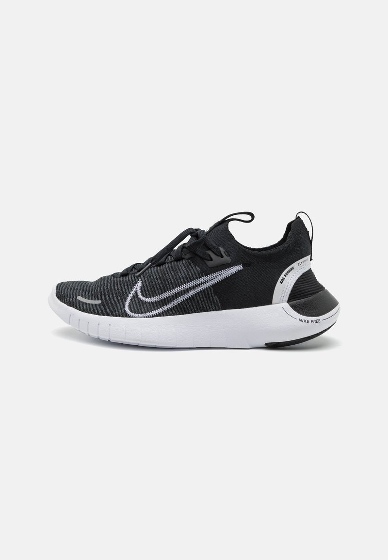 Chaussure de running Nike noire et blanche avec empeigne tricotée, semelle blanche et logo Nike sur le côté, vue de profil droit sur fond uni.