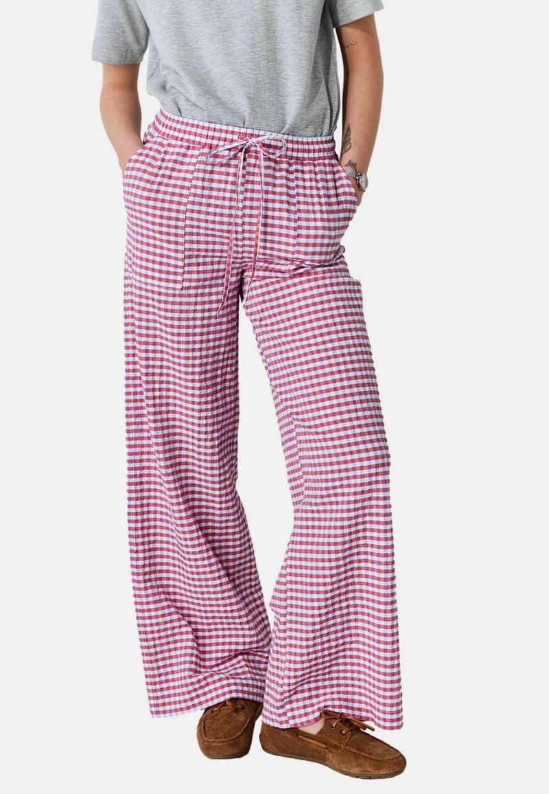 Rood-wit geruite, wijde broek met een elastische tailleband en koord. Gemaakt van lichtgewicht stof, met twee zijzakken.