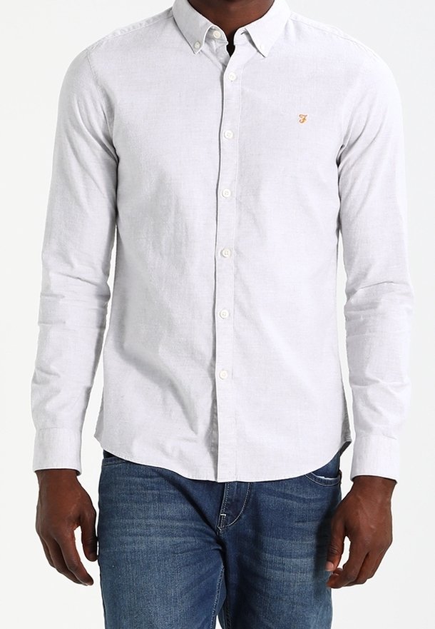 Camisa de botones de color gris claro con mangas largas, hecha de lino, que presenta un pequeño logotipo bordado en el lado izquierdo del pecho. Diseño de cuello estándar.