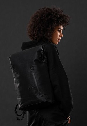 Schwarzer Rolltop-Rucksack aus strapazierfähigem Material, mit vorderer Reißverschlusstasche, verstellbaren Gurten und einem dezenten, seitlich eingeprägten Logo.