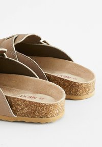 Brune sandaler med stropdesign, korksål, tekstureret fodseng og synligt mærkenavn indeni. Blødt materiale og afrundet hæl.